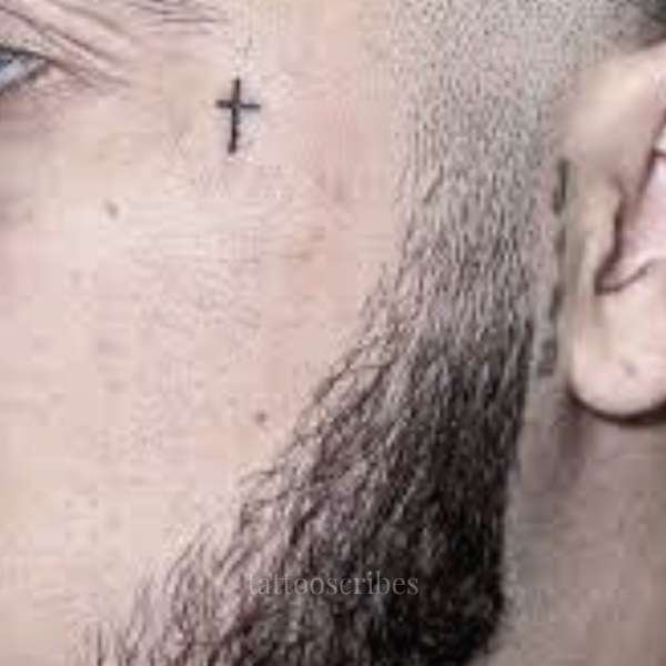 cross tattoo under the eye meaning